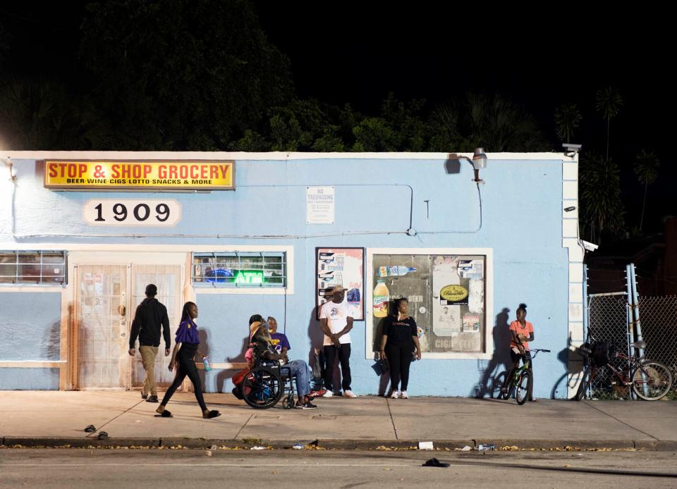 Members of the community stand out the Stop & Shop Grocery during the PUSH to Curb Gun Violence block party Friday night on Tamarind Avenue in West Palm Beach.