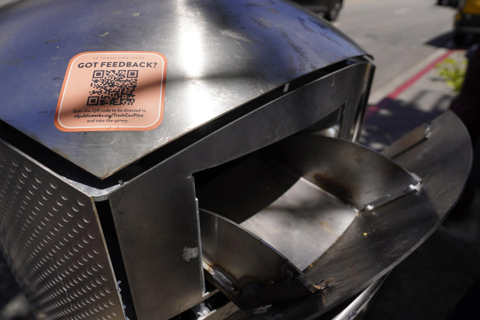 A sticker asking for feedback is seen on the top of a prototype Soft Square trash can in the North Beach area of San Francisco on July 26, 2022. What takes years to make and costs more than $20,000? A trash can in San Francisco. The pricey, boxy bin is one of three custom-made trash cans the city is testing this summer as part of its yearslong search for another tool to fight its battle against dirty streets. (AP Photo/Eric Risberg)