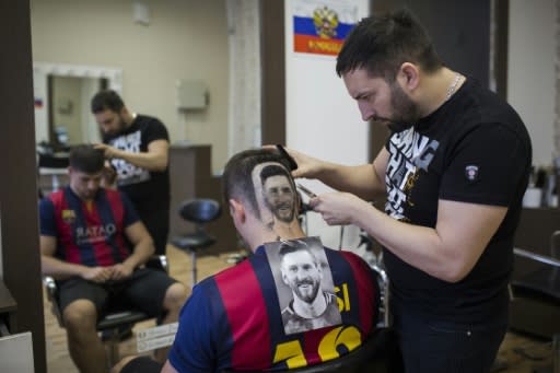 Serbian hairdresser Mario Hvala creates a portrait of Argentinian star Lionel Messi with the hair a World Cup football fan in Novi Sad, June 10, 2018