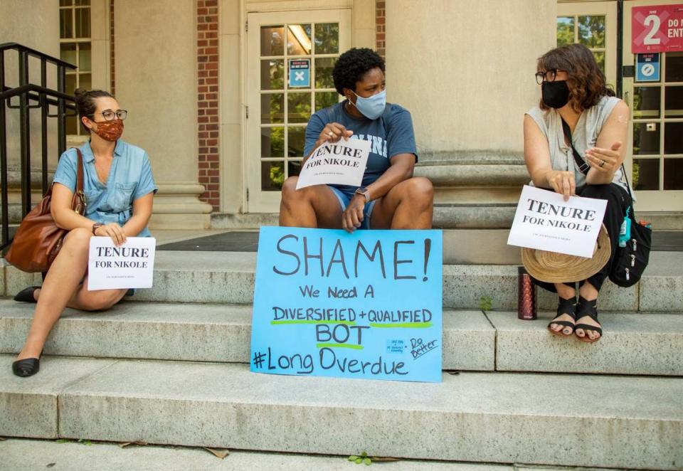 From left, Sarah Miles, a current graduate student, Carol Shirley, an alumni, and Deborah Dwyer, a doctoral candidate, gather on the steps of Carroll Hall, where the UNC-Chapel Hill Hussman School of Journalism and Media is located, before the university’s Board of Trustees is scheduled to vote on tenure for distinguished journalist Nikole Hannah-Jones, on Wednesday, Jun. 30, 2021, in Chapel Hill, N.C.