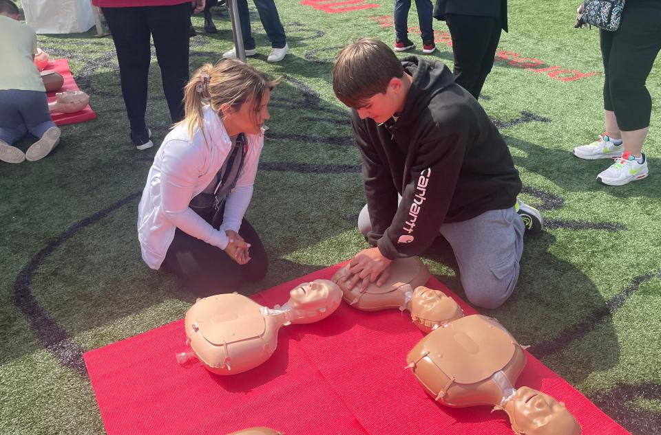 American Heart Association project coordinator Sarah Bennett, 34, of Dallas, Texas, teaches Jonathan Barnett, 14, of Dearborn Heights, how to perform CPR on day 3 of the NFL draft in Detroit, on April 27, 2024.