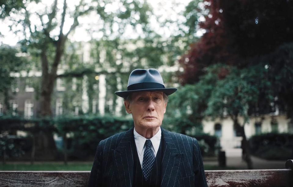 Bill Nighy sits on a park bench