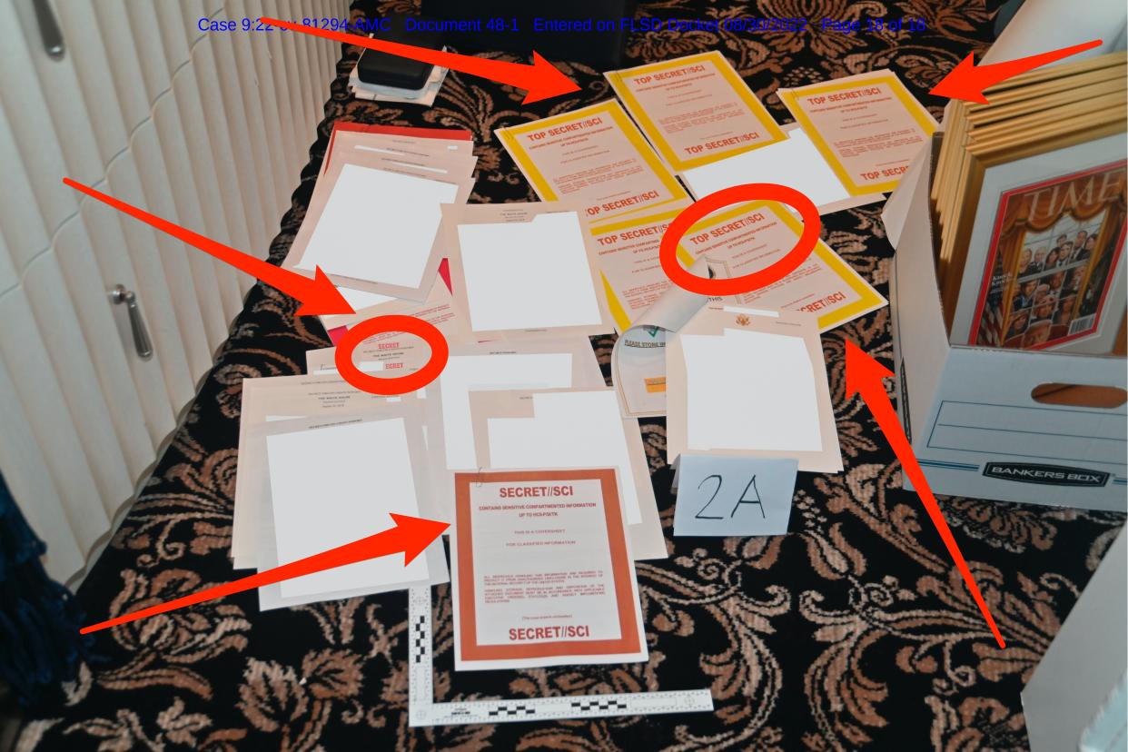 Photo of documents seized by FBI at Mar-a-Lago strewn across the floor, with red circles and arrows pointing to the ones with classification markings.