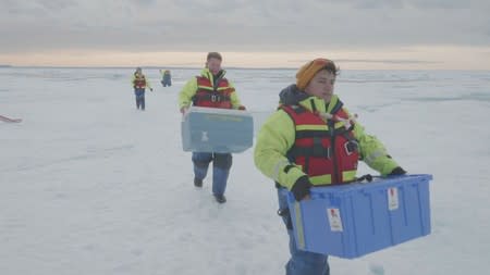 Scientists from the U.S.-led Northwest Passage Projectcarry boxes of ice cores drilled from the Canadian Arctic during an 18-day icebreaker expedition that took place in July and August 2019