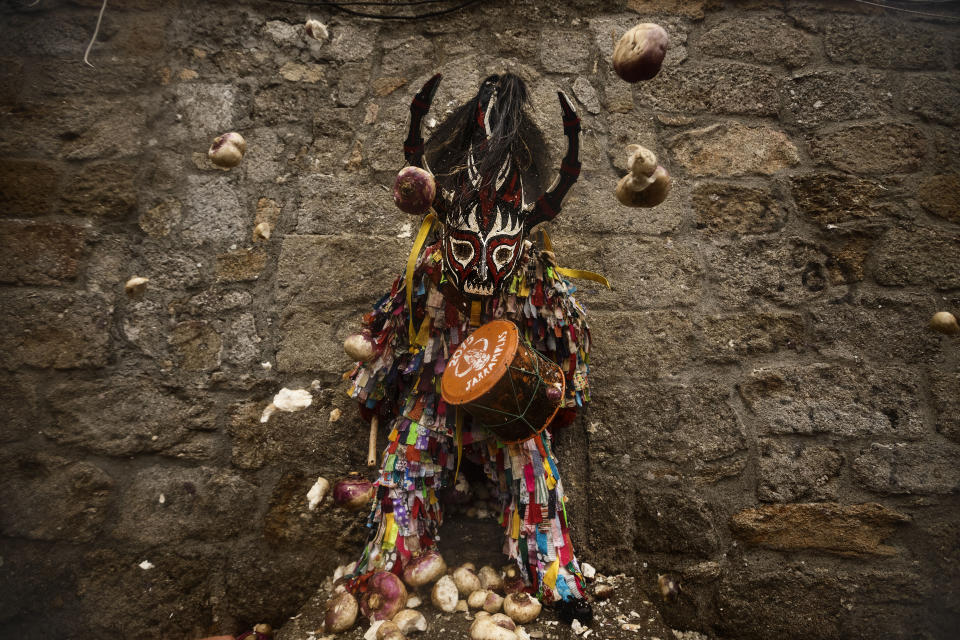 <p>People throw turnips at the Jarramplas as he makes his way through the streets beating his drum during the Jarramplas Festival in Piornal, Spain, Jan. 20, 2015. (Photo: Daniel Ochoa de Olza/AP) </p>