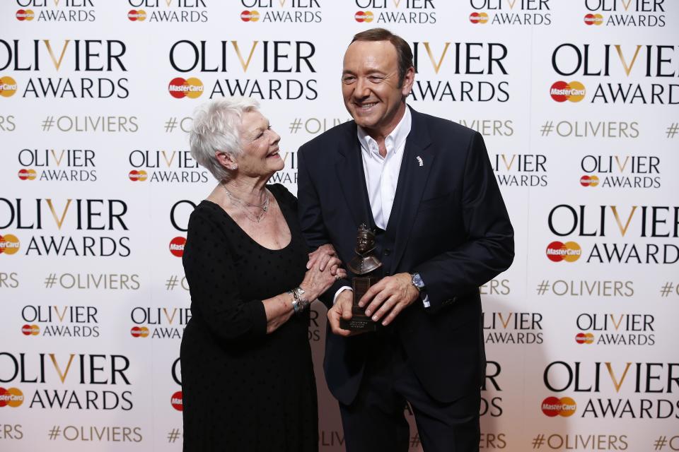 US actor, producer and director Kevin Spacey (R) poses with a special award recognising his contribution to British theatre during his tenure as Artistic Director of The Old Vic with British actress Judi Dench (L) during the Lawrence Olivier Awards for theatre at the Royal Opera House in central London on April 12, 2015.   AFP PHOTO / JUSTIN TALLIS        (Photo credit should read JUSTIN TALLIS/AFP/Getty Images)