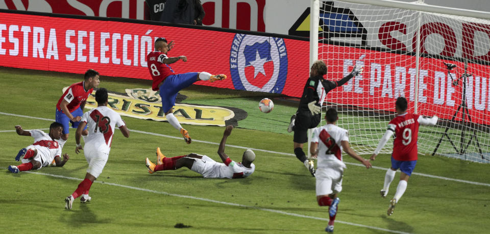 Chile's Arturo Vidal, center above, scores his side's second goal against Peru during a qualifying soccer match for the FIFA World Cup Qatar 2022 in Santiago, Chile, Friday, Nov. 13, 2020. (AP Photo/Esteban Felix)