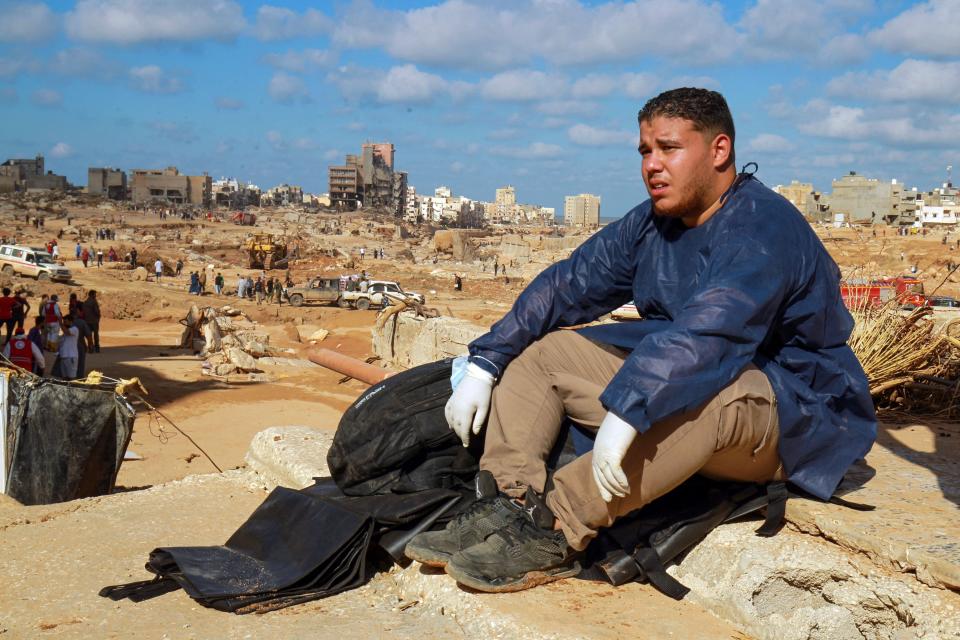 A volunteer sits on the rubble of a building in a flash flood-damaged area in Derna on September 14, 2023. (Abdullah Doma /AFP via Getty Images)