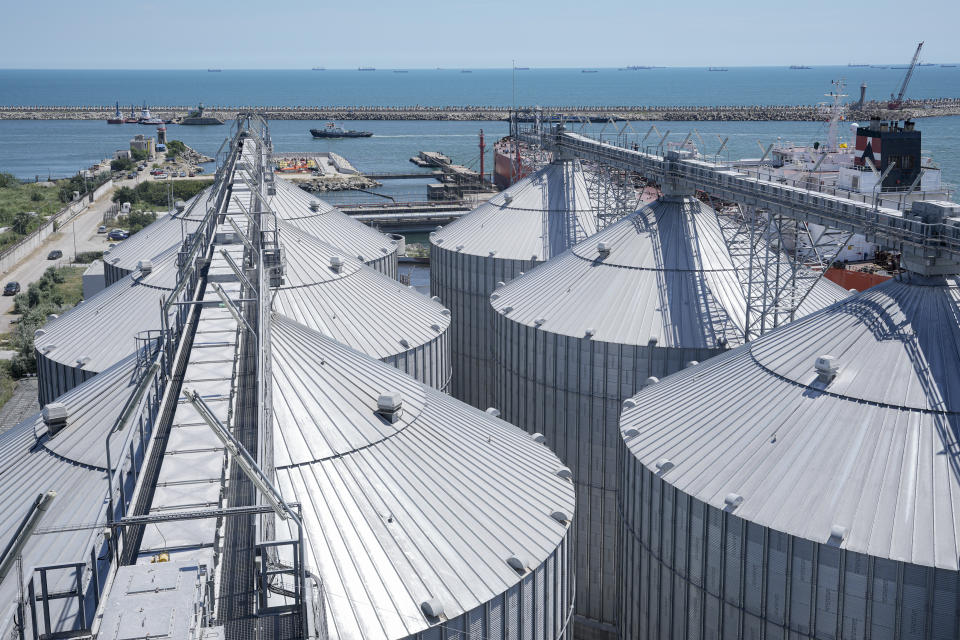 A pilot ship sails behind silos at the Comvex handling and storage facility in the Black Sea port of Constanta, Romania, Tuesday, June 21, 2022. While Romania has vocally embraced the ambitious goal of turning into a main hub for the export of agricultural products from Ukraine, economic experts and port operators in the country warn that it was much easier objective to set than to actually achieve. (AP Photo/Vadim Ghirda)