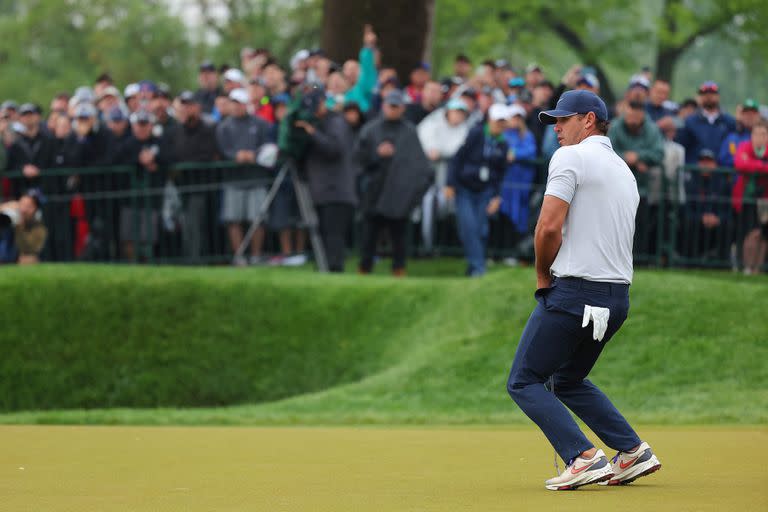 El puntero hace fuerza para que la pelota entre al hoyo 18; este domingo puede conquistar por quinta vez un major de golf.