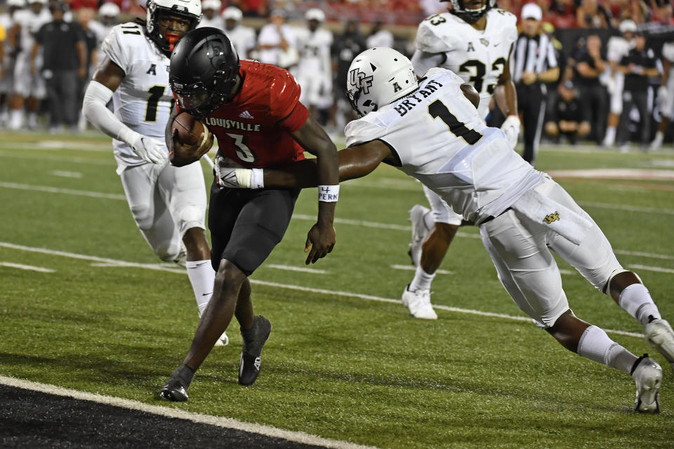 Central Florida defensive lineman Big Kat Bryant (1) attempts to tackle Louisville quarterback Malik Cunningham (3) who scores a touchdown during the second half of an NCAA college football game in Louisville, Ky., Friday, Sept. 17, 2021. (AP Photo/Timothy D. Easley)