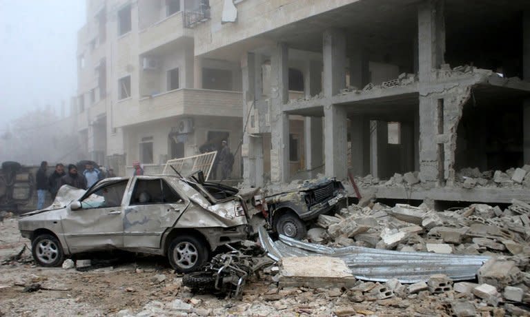 A handout picture released by the Syrian Arab News Agency (SANA) shows Syrians inspecting the site of a suicide car bombing in Salmiyeh, a town in the central province of Hama, on January 22, 2013