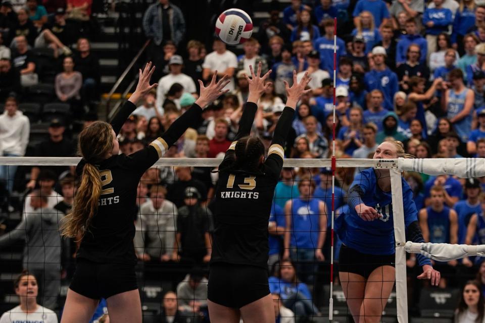 Pleasant Grove’s Ashley Gneiting, right, hits the ball as Lone Peak’s Kelli Jo Burgess and Zoey Burgess (13) reach for a block in the 6A volleyball state championship at the UCCU Center in Orem on Saturday, Nov. 6, 2021. | Shafkat Anowar, Deseret News