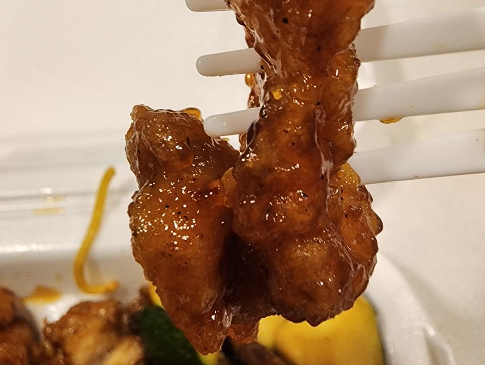 A piece of orange chicken on a fork