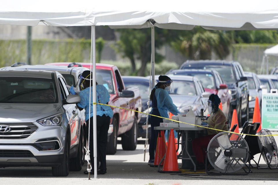 People wait in cars to get a COVID-19 test, Wednesday, Aug. 11, 2021, in Miami. COVID-19 has strained some Florida hospitals so much that ambulance services and fire departments can no longer respond as usual to every call. (AP Photo/Marta Lavandier)