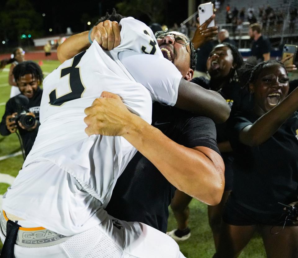 Golden Gate Titans head coach Nick Bigica hugs running back John Lee Honorat (3) after they defeated the Naples Golden Eagles 30-19 in a district game at Staver Field in Naples on Thursday, Sept. 14, 2023.