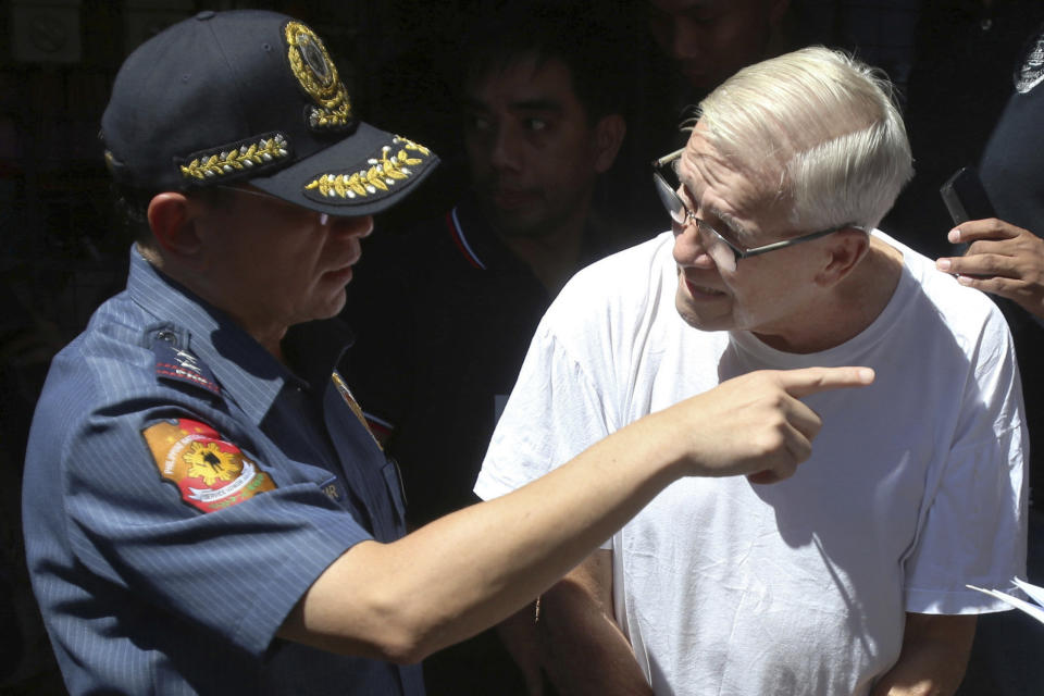 In this Feb. 19, 2019, photo, Philippine National Police, National Capital Region Police Chief Maj. Gen. Guillermo Eleazar, left, talks to Catholic priest Father Pius Hendricks prior to being served five more arrest warrants at the Regional Special Operations Unit at Camp Bagong Diwa in suburban Taguig, east of Manila, Philippines. Investigators say about 20 boys and men, one as young as 7, have accused the priest of sexual abuse at his parish in Talustosan village, Naval township, Biliran province in central Philippines. (AP Photo)