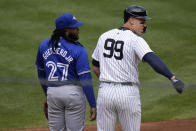 Toronto Blue Jays first base Vladimir Guerrero Jr., left, watches as New York Yankees' Aaron Judge looks back at his teammates during first inning of a home-opener baseball game at Yankee Stadium, Friday, April 5, 2024, in New York. (AP Photo/Seth Wenig)