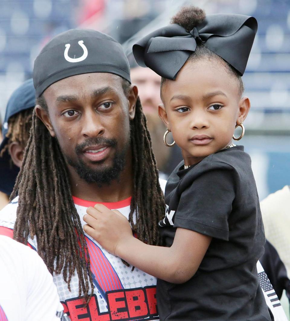 Team Flutie’s T.Y. Hilton, Indianapolis Colts wide receiver, holds his daughter during the 20th annual Super Bowl Celebrity Flag Football Challenge on Saturday at FIU.