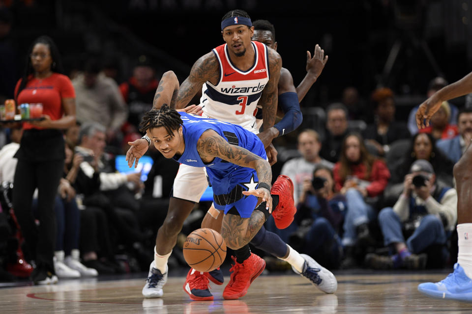 Orlando Magic guard Markelle Fultz, front, chases a loose ball in front of Washington Wizards guard Bradley Beal (3) during the first half of an NBA basketball game Wednesday, Jan. 1, 2020, in Washington. (AP Photo/Nick Wass)
