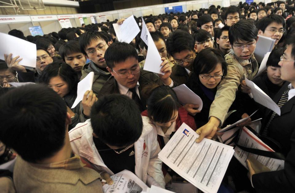 A group of jobseekers rush to put in their applications as thousands of unemployed Chinese graduates flock to a job fair in Wuhan, central China's Hubei province on March 7, 2009.  China vowed to help train one million unemployed graduates in the next three years to boost their qualifications, and promised loans to business that hire graduates and to graduates seeking to start businesses, as unemployment stemming from the world financial crisis grow with at least 20 million migrant workers had already lost their jobs.     CHINA OUT GETTY OUT        AFP PHOTO        (Photo credit should read STR/AFP/Getty Images)