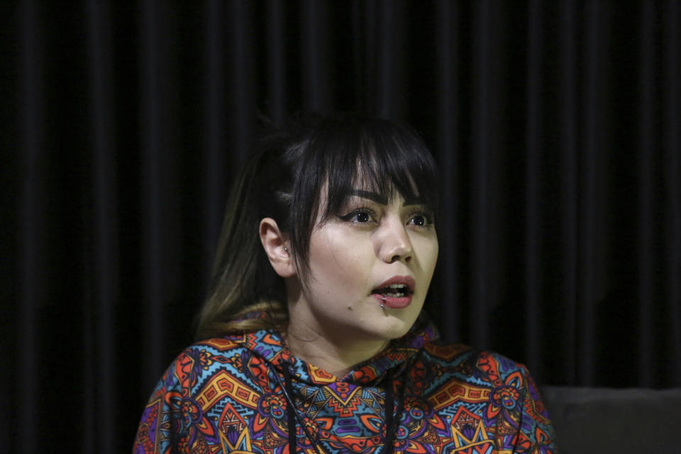 In this Saturday, 9, 2019, photo, Suraya Shaheedi, 26, Tattoo artist, speaks during an interview to The Associated Press after pierced tattoo to her male customer in Kabul, Afghanistan. It’s been 18 months since Shaheedi started her mobile tattoo shop in the capital, Kabul. She’s received death threats for taking on the taboo of the ink-on-skin drawings she does — as well as being a single woman willing to work with men. (AP Photo/Rahmat Gul)