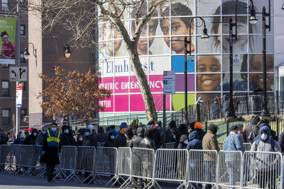 People line up outside Elmhurst Hospital Center to be tested for the coronavirus, Tuesday, March 24, 2020, in the Queens borough of New York. New York Gov. Andrew Cuomo says the number of positive coronavirus cases in the state surged to more than 20,000, with more than half the cases in New York City. Cuomo promised 1,000 temporary hospital beds will be swiftly placed inside a vast Manhattan convention center as officials raced to prepare for an overwhelming number of coronavirus patients. (AP Photo/Mary Altaffer)