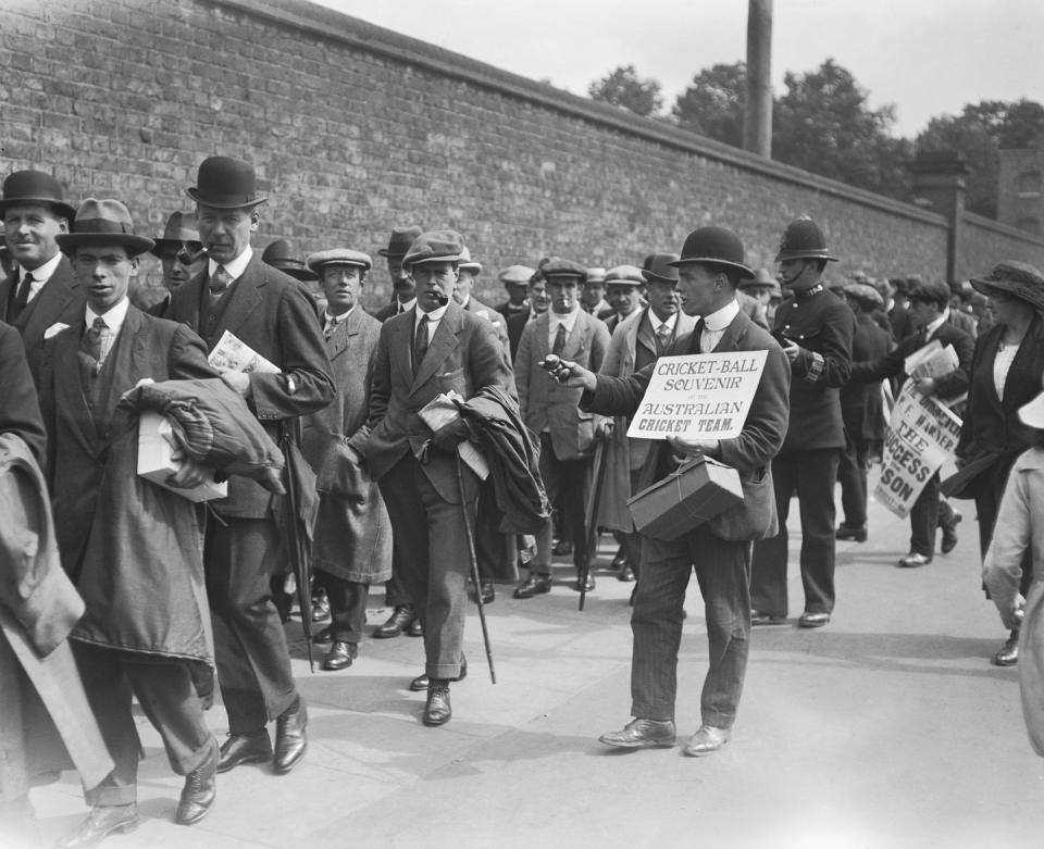 <p>A street salesman offers up cricket ball souvenirs to bystanders waiting outside an Australian cricket game.</p>