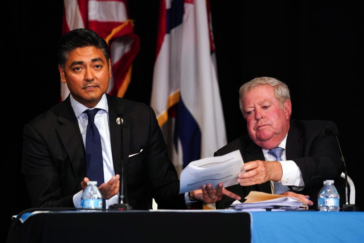 Paul Muething, president of the Cincinnati Southern Railway Board of Trustees, hands Cincinnati Mayor Aftab Pureval documents during a town hall hosted by The Cincinnati Enquirer on the proposed sale of the Cincinnati Southern Railway to Norfolk Southern Corp,
