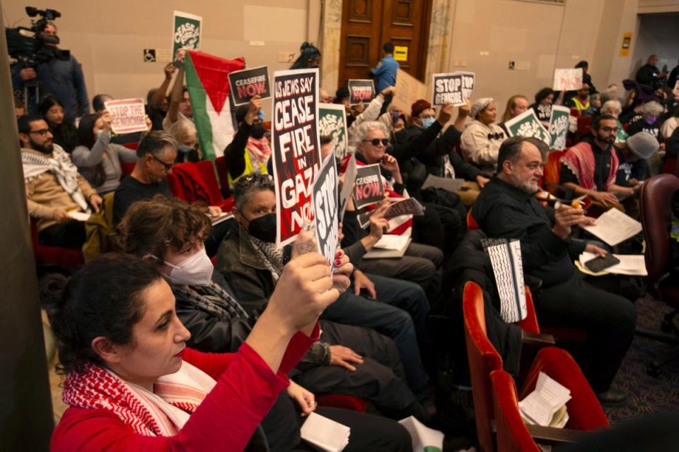 Audience members show their support at a special session of the Oakland City Council for a resolution calling for an immediate cease-fire in Gaza (AP)