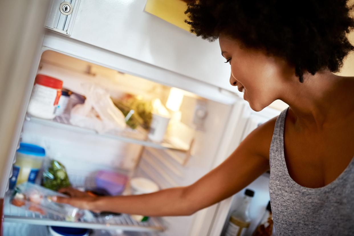 woman looking in refrigerator