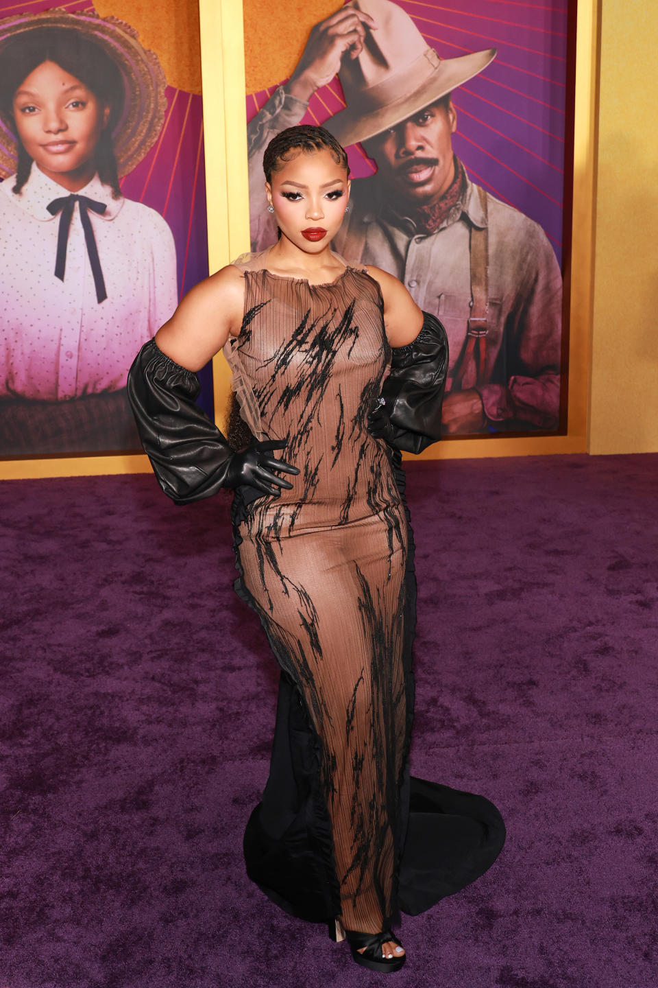 Close-up of Chloe in a sheer sleeveless black and brown print gown with small train