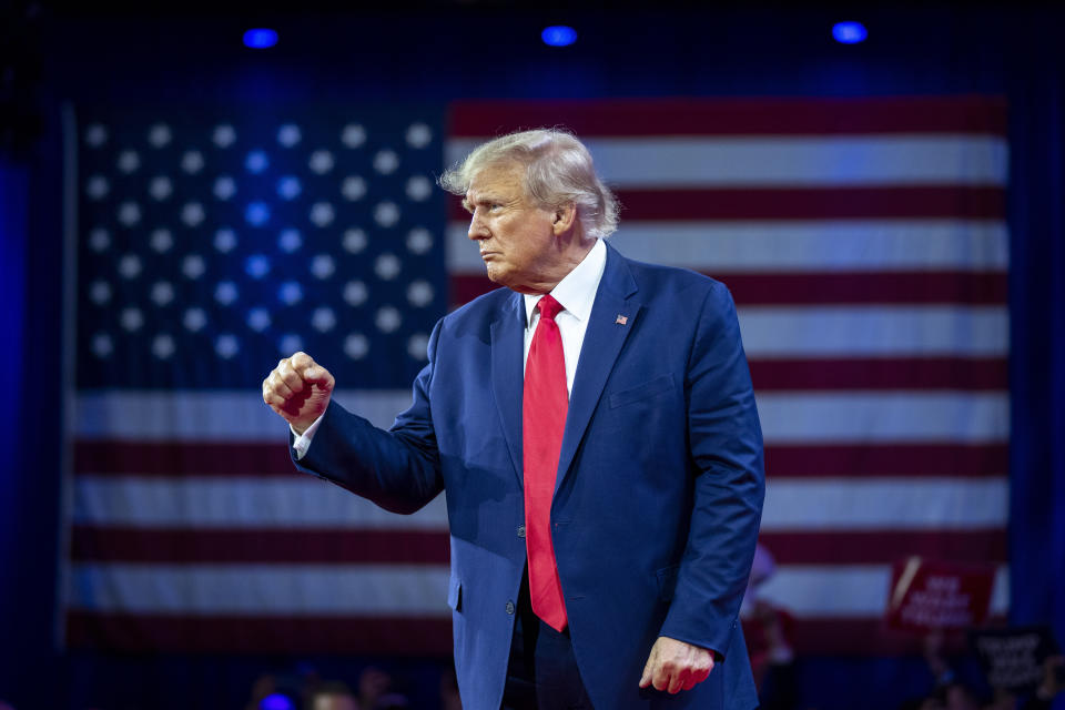 Former President Donald Trump looks determined, with a Stars and Stripes in the background.