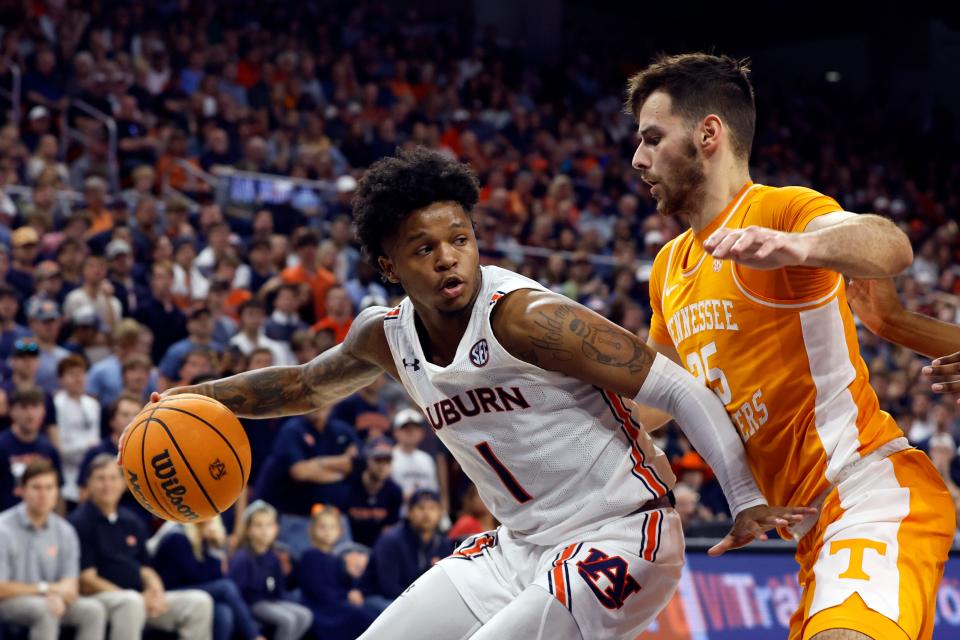 Auburn guard Wendell Green Jr. (1) dribbles as Tennessee guard Santiago Vescovi (25) blocks out during the second half of an NCAA college basketball game Saturday, March 4, 2023, in Auburn, Ala. (AP Photo/Butch Dill)