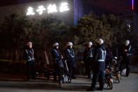 Liu Pengfei, a substitute driver of ride-hailing service platform DiDi Chuxing and his team of fellow drivers wait for clients near a cluster of restaurants in Beijing