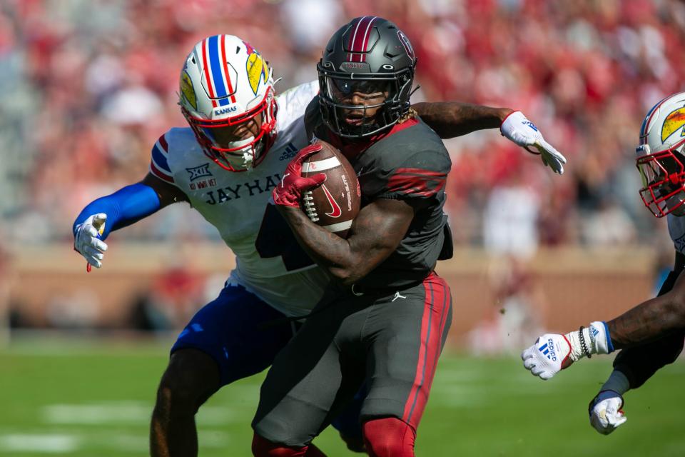 Oklahoma running back Eric Gray (0) holds the ball as Kansas safety Marvin Grant (4) prepares to tackle him during the first quarter of a game between the Sooners and Jayhawks on Saturday in Norman, Okla.