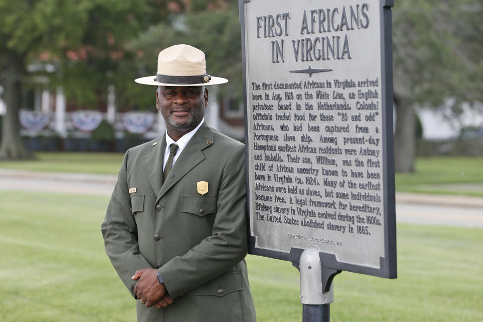 Terry E. Brown, Superintendent of the Fort Monroe National Monument poses next to a historical marker that signifies the spot of the first landing of Africans in America 400 years ago at Fort Monroe in Hampton, Va., Thursday, Aug. 15, 2019. (AP Photo/Steve Helber)