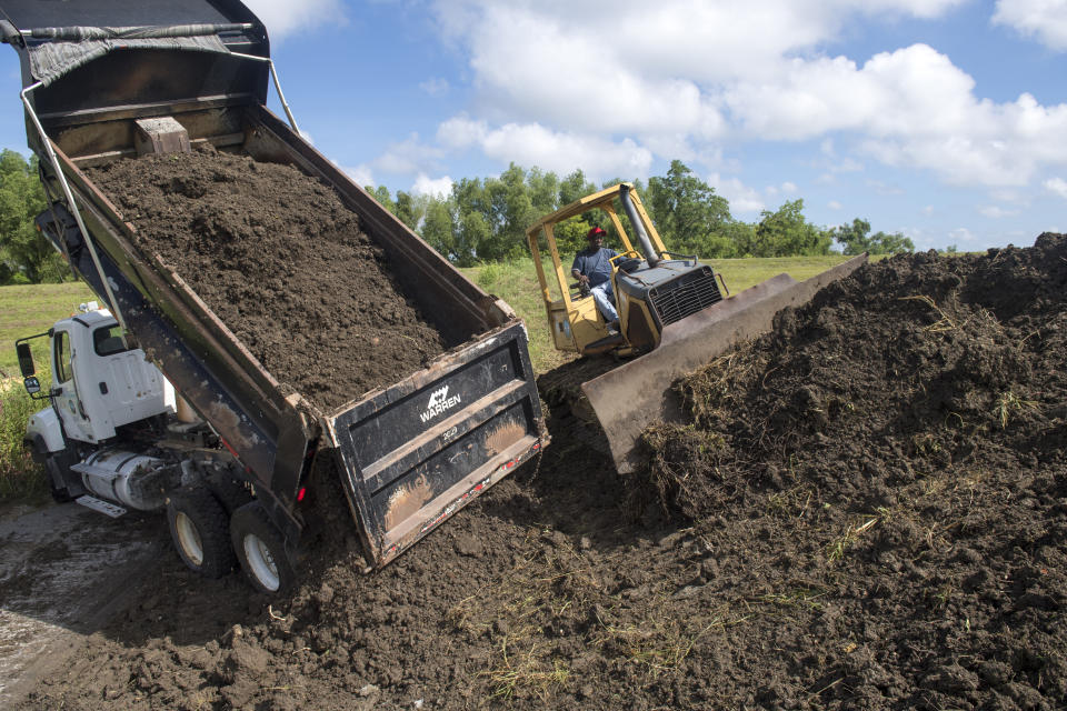 Plaquemines Parish road crews add more dirt to the top of a levee near the Mississippi River levee, back, and the St. Bernard Parish line as they prepare for potential flooding from Tropical Storm Barry in Braithwaite, La., on Thursday, July 11, 2019. (Chris Granger/The Advocate via AP)