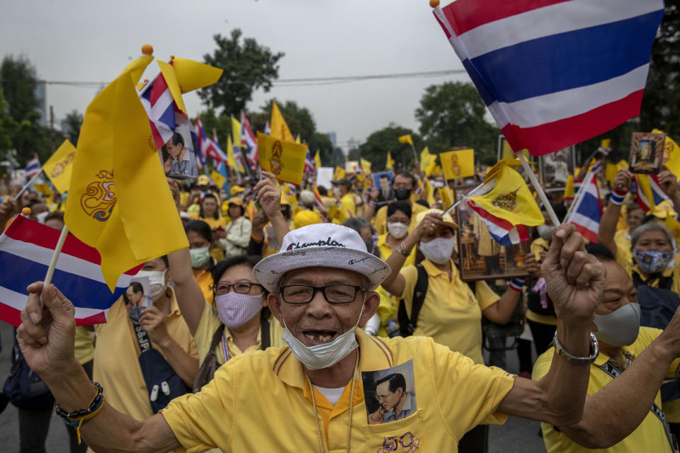 Supporters of the Thai monarchy wave national flags and sing during a rally at Lumphini park in central Bangkok, Thailand, Tuesday, Oct. 27, 2020. Hundreds of royalists gathered to oppose pro-democracy protesters' demands that the prime minister resign, constitution be revised and the monarchy be reformed in accordance with democratic principles. (AP Photo/Gemunu Amarasinghe)