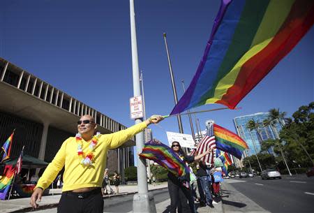 Don Fasone waves a flag in support of same sex marriage while the Hawaii State Senate convenes to approve the bill allowing same sex marriage to be legal in the state of Hawaii in Honolulu, November 12, 2013. REUTERS/Hugh Gentry