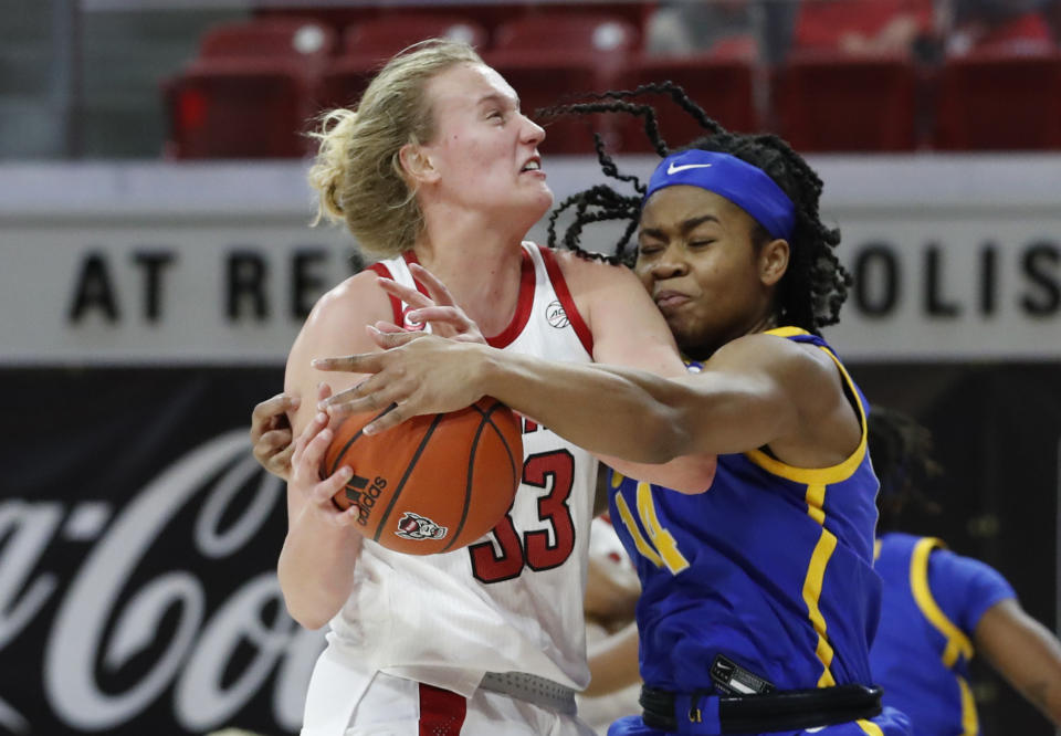 Pittsburgh's Cynthia Ezeja (14) knocks the ball from the hands of North Carolina State's Elissa Cunane (33) during the first half of an NCAA college basketball game, Thursday, Feb. 25, 2021 in Raleigh, N.C. (Ethan Hyman/The News & Observer via AP, Pool)