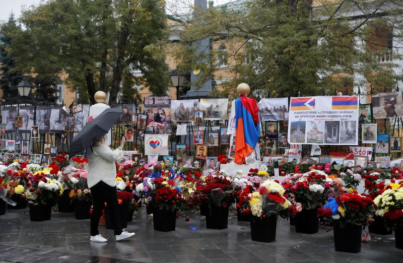 A woman visits a makeshift memorial outside the Armenian embassy for people killed during a military conflict over the breakaway region of Nagorno-Karabakh in Moscow
