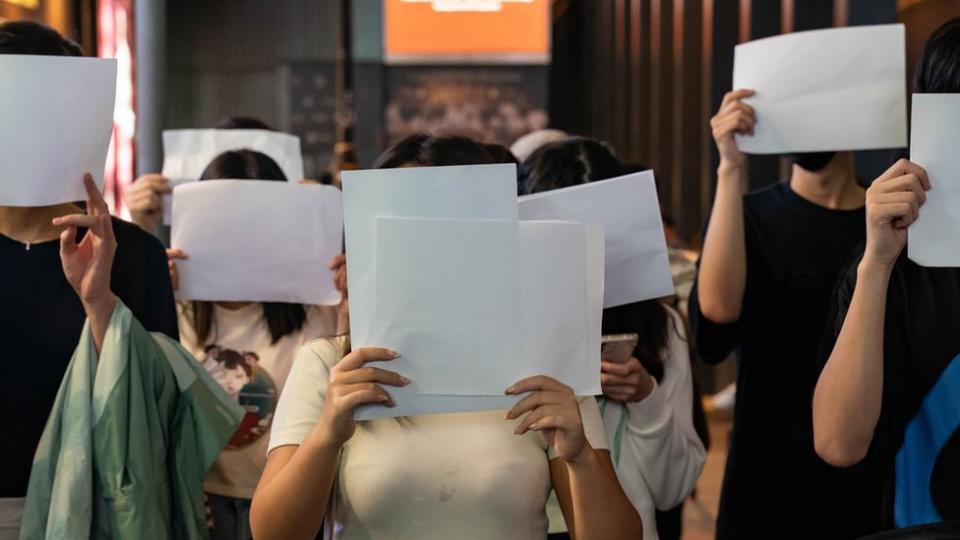 People protesting in China with blank pieces of paper.