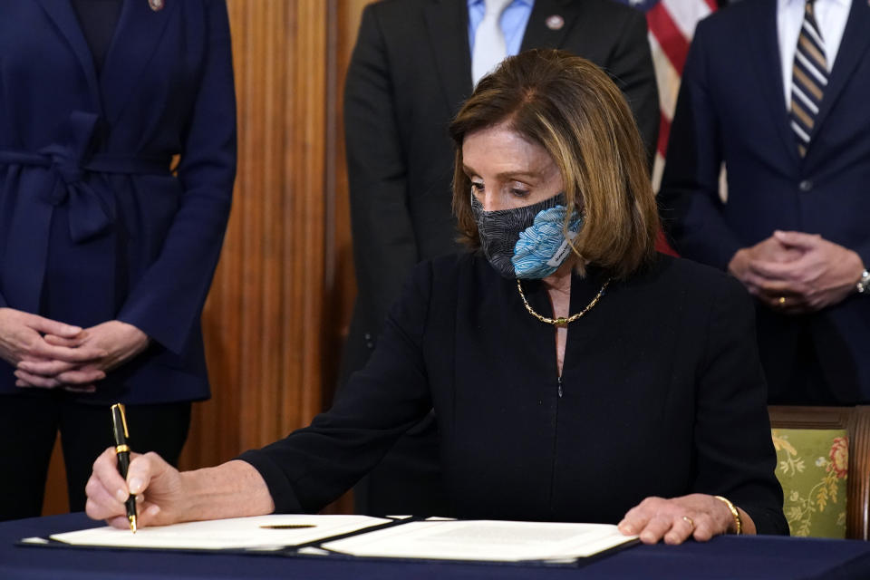 House Speaker Nancy Pelosi of Calif., signs the article of impeachment against President Donald Trump in an engrossment ceremony before transmission to the Senate for trial on Capitol Hill, in Washington, Wednesday, Jan. 13, 2021. (AP Photo/Alex Brandon)