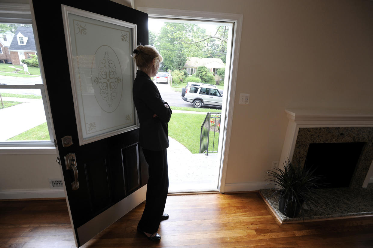 Real estate agent Sheila Power stands at the door as she holds an open house at a home for sale. (Credit: Jonathan Ernst, REUTERS)