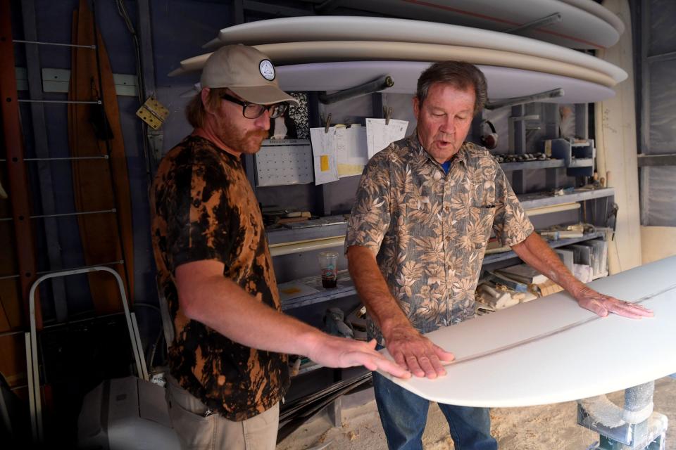 Surfboard shaper Johnny Gianelli, left, talks with Bill "Blinky" Hubina, 79, owner of Ventura Surf Shop, about finishing touches to put on a board on Nov. 12.
