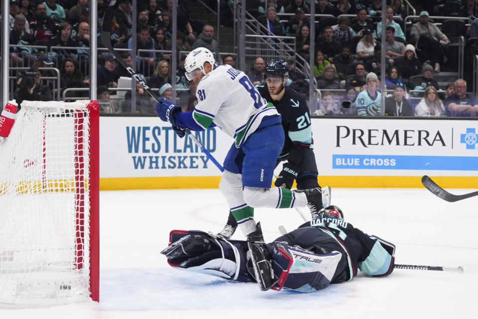 Vancouver Canucks center Dakota Joshua (81) skates away after scoring against Seattle Kraken goaltender Joey Daccord as center Alex Wennberg (21) watches during the second period of an NHL hockey game Friday, Nov. 24, 2023, in Seattle. (AP Photo/Lindsey Wasson)