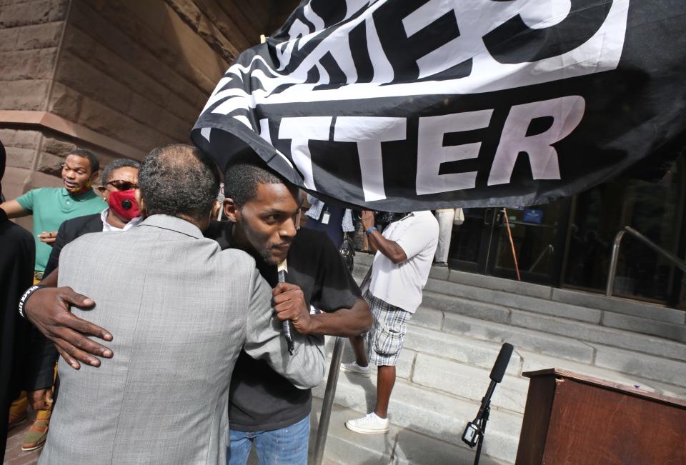 Abdul Bounds, right, with Save Rochester, gets a hug from Rev. Lewis Stewart  after his press conference with members of the United Christian Leadership Ministries on the steps outside City Hall in downtown Rochester Thursday, Sept. 3, 2020.  Rev. Lewis called on the city and Rochester police for change following news that a black man died after being restrained by Rochester Police in March.