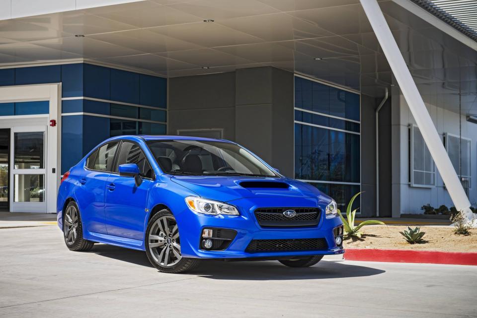 A blue Subaru WRX parked outside a building.