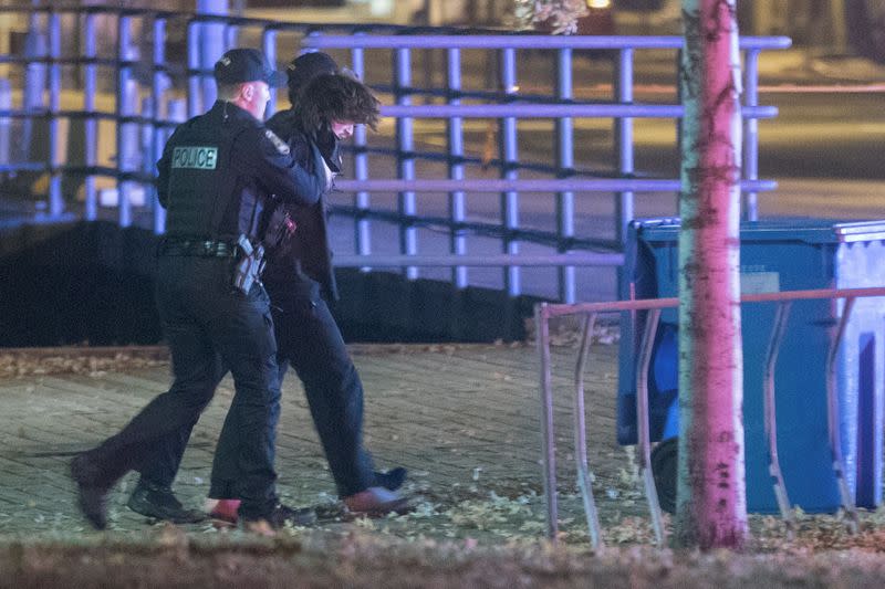 Police officers detain a man in an area where multiple people were stabbed near the Parliament Hill area of Quebec City